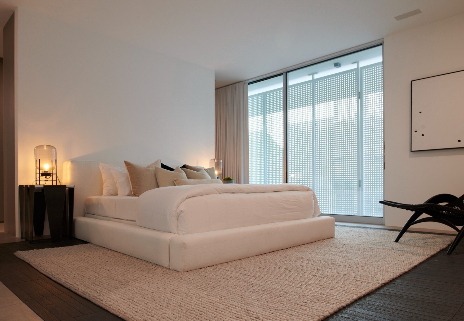 Primary bedroom at Asteras Kings with modern decor and floor-to-ceiling windows.