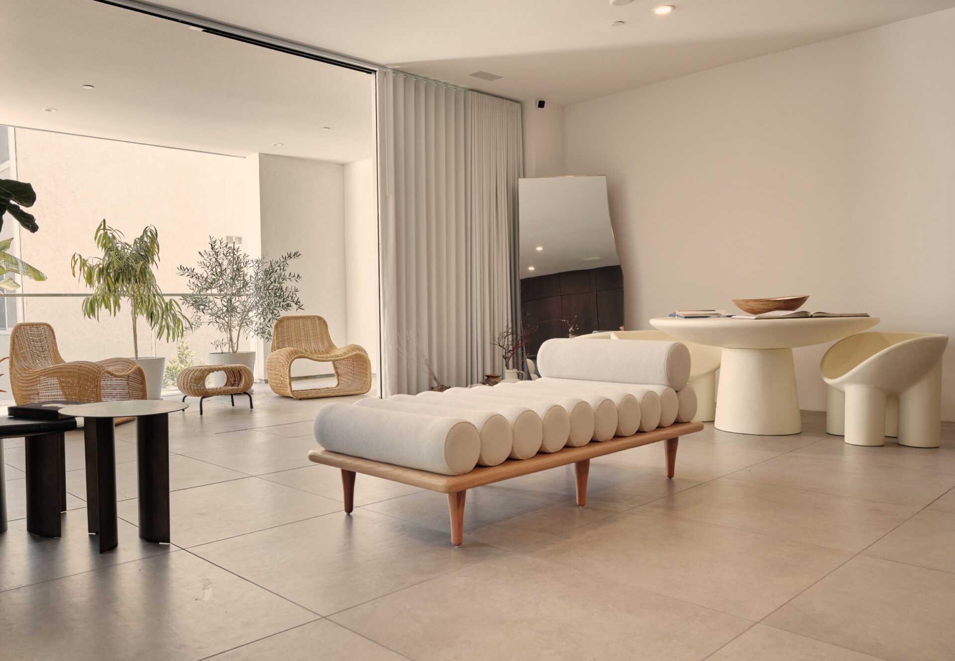 Corner one-bedroom residence with minimalist furniture and seamless indoor-outdoor flow from living room to private terrace.