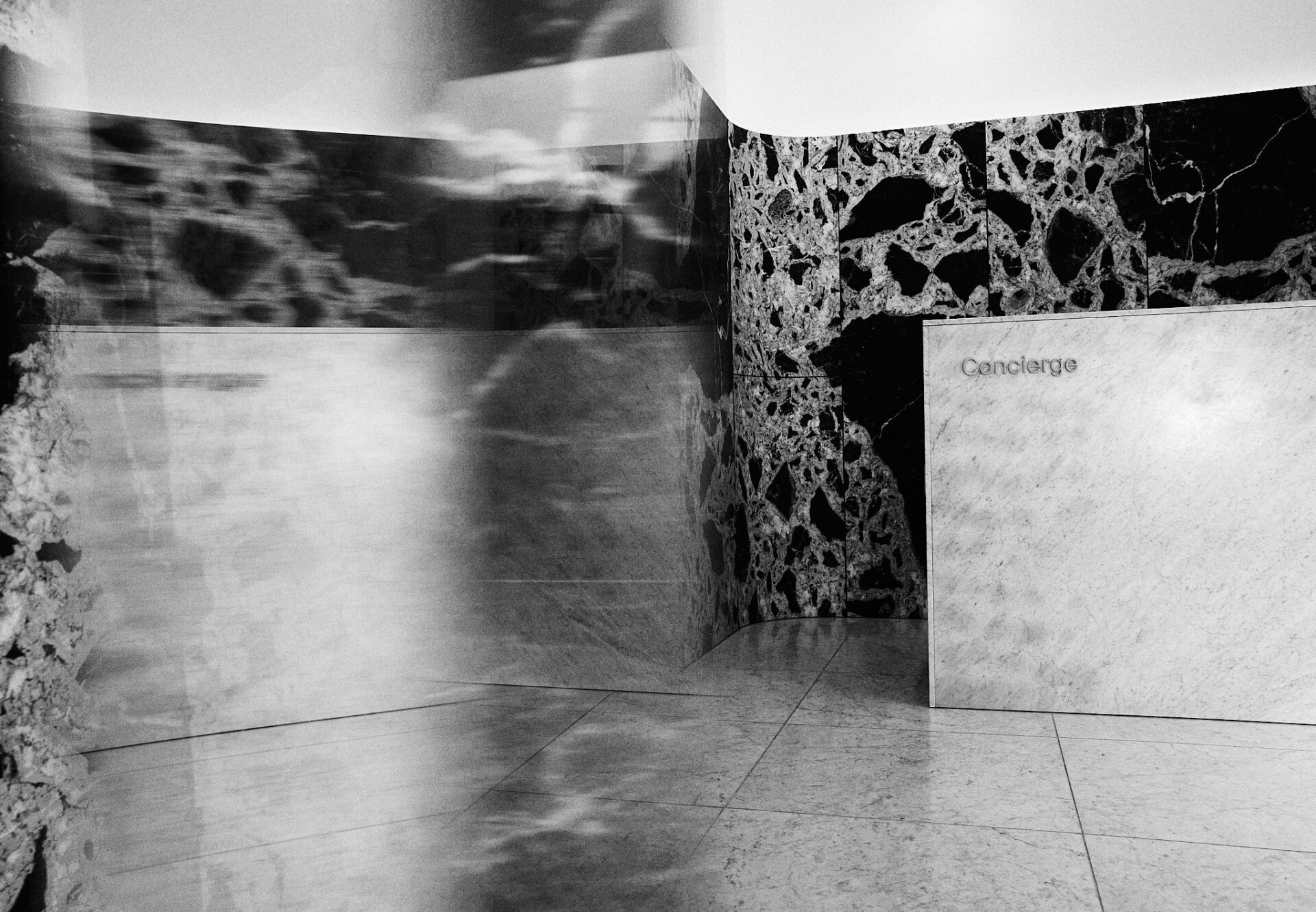 Luxury Asteras Kings lobby with white marble concierge desk and striking black-and-white marble feature wall.