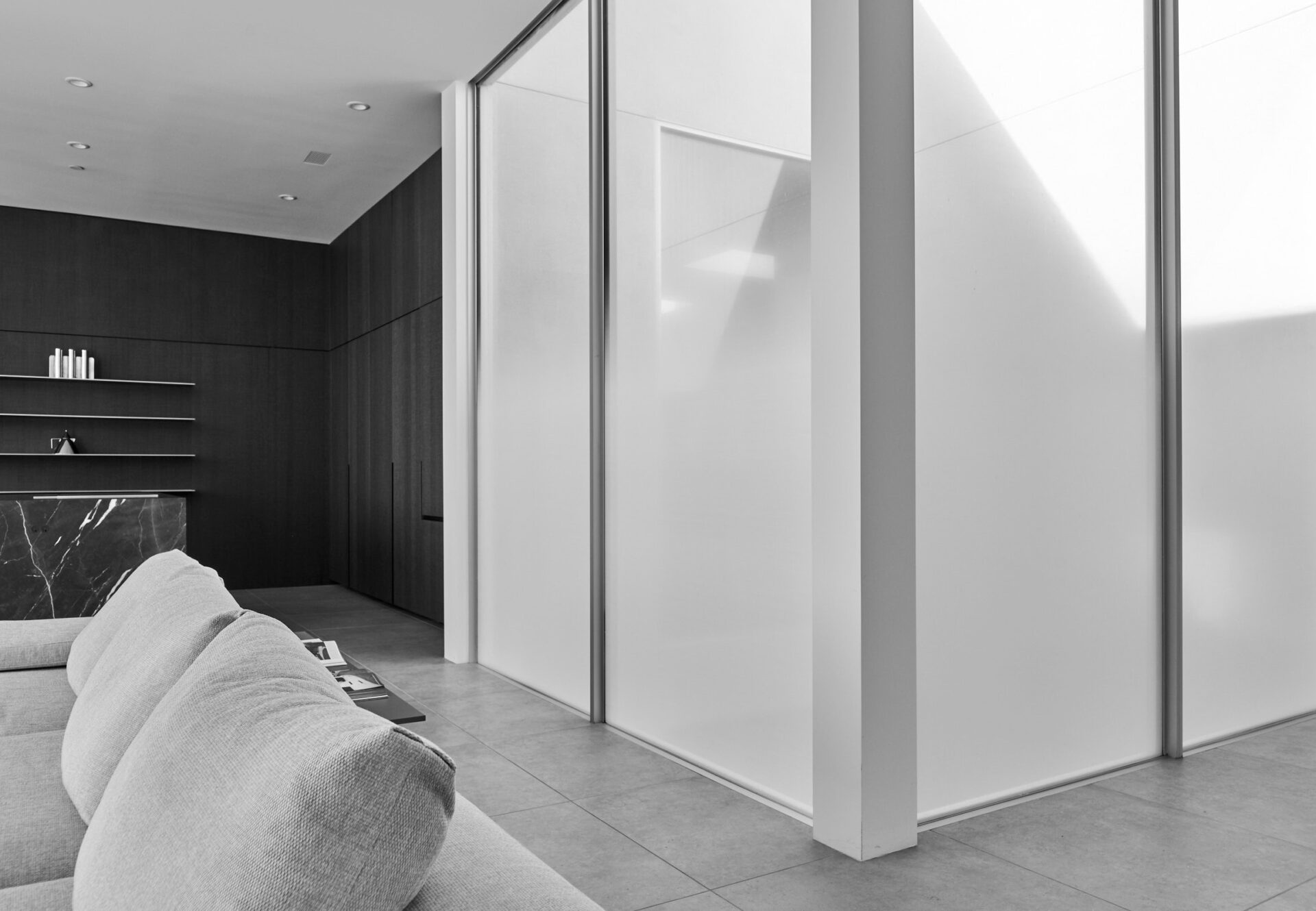 Luxury penthouse two-bedroom with sunlit central atrium, living room, dark wood kitchen, minimalist architecture, and natural light.