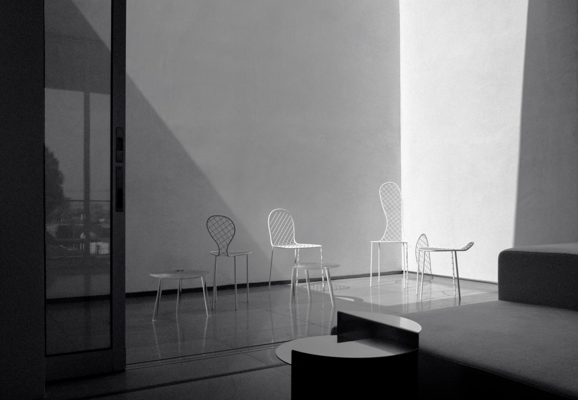 Interior courtyard in a penthouse two-bedroom, featuring sculptural white seating in a minimalist setting with dramatic light.