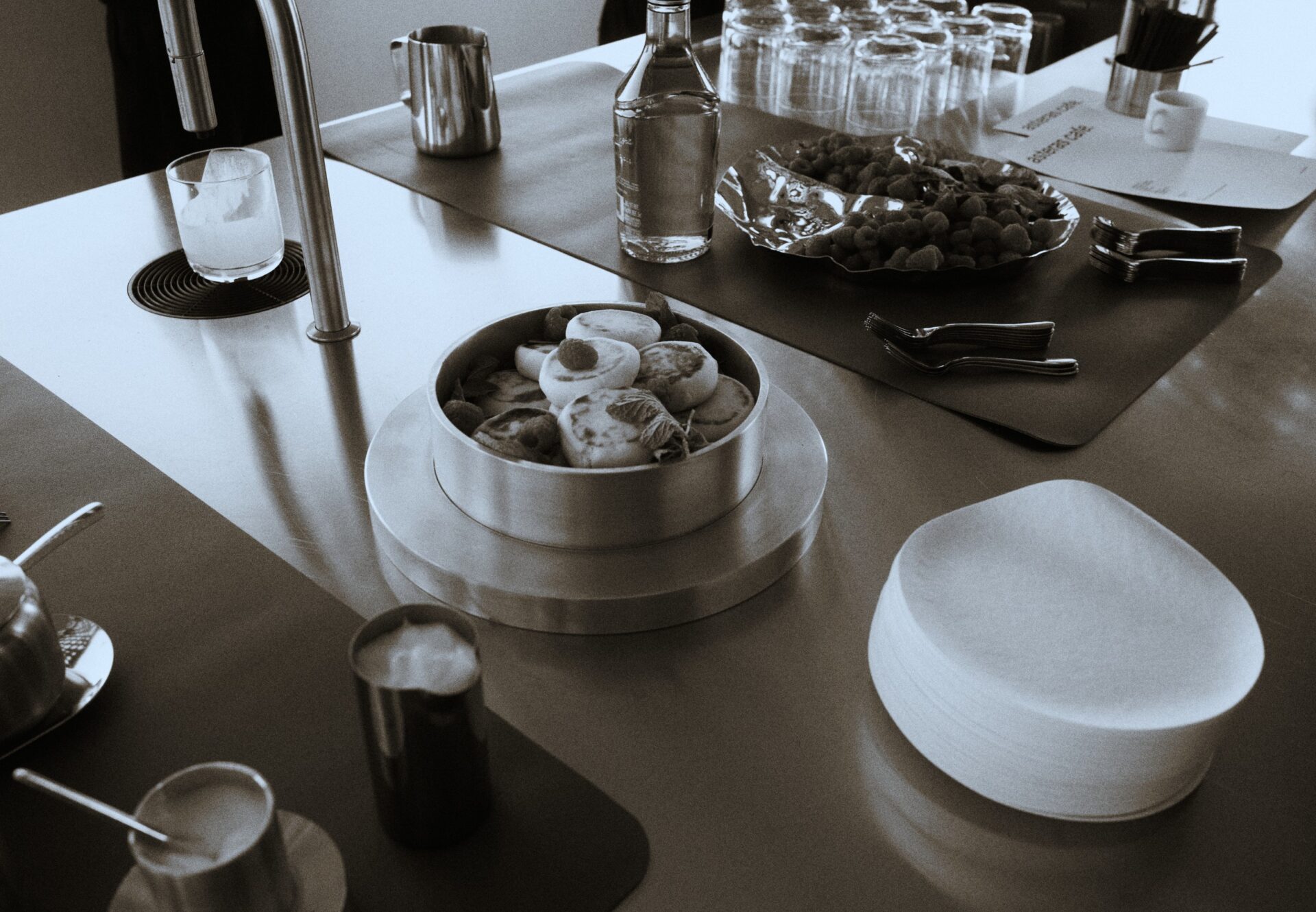 Pastries, coffee, and glassware set on the café bar at a rooftop resident event, highlighting the building’s social lifestyle.