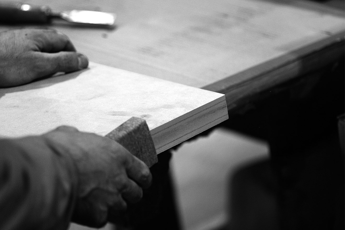 Close-up of a craftsman sanding the edge of a wooden board for Asteras Kings in West Hollywood