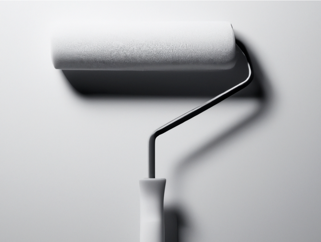 Close-up of a paint roller applying a fresh coat of white paint on a smooth wall